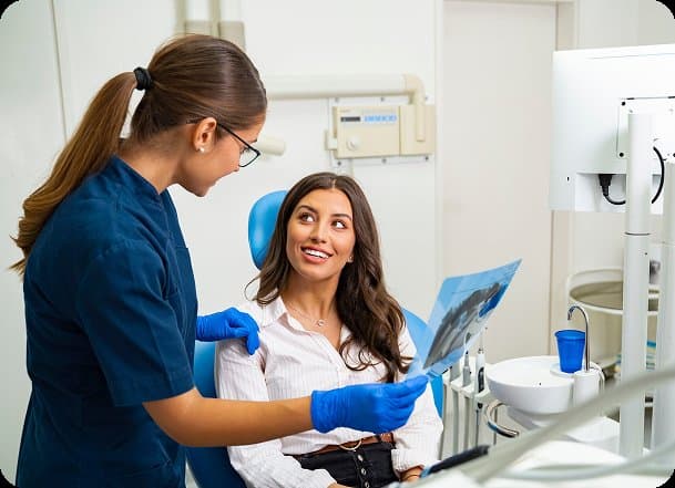 A dentist talking a smiling patient through their X-ray
