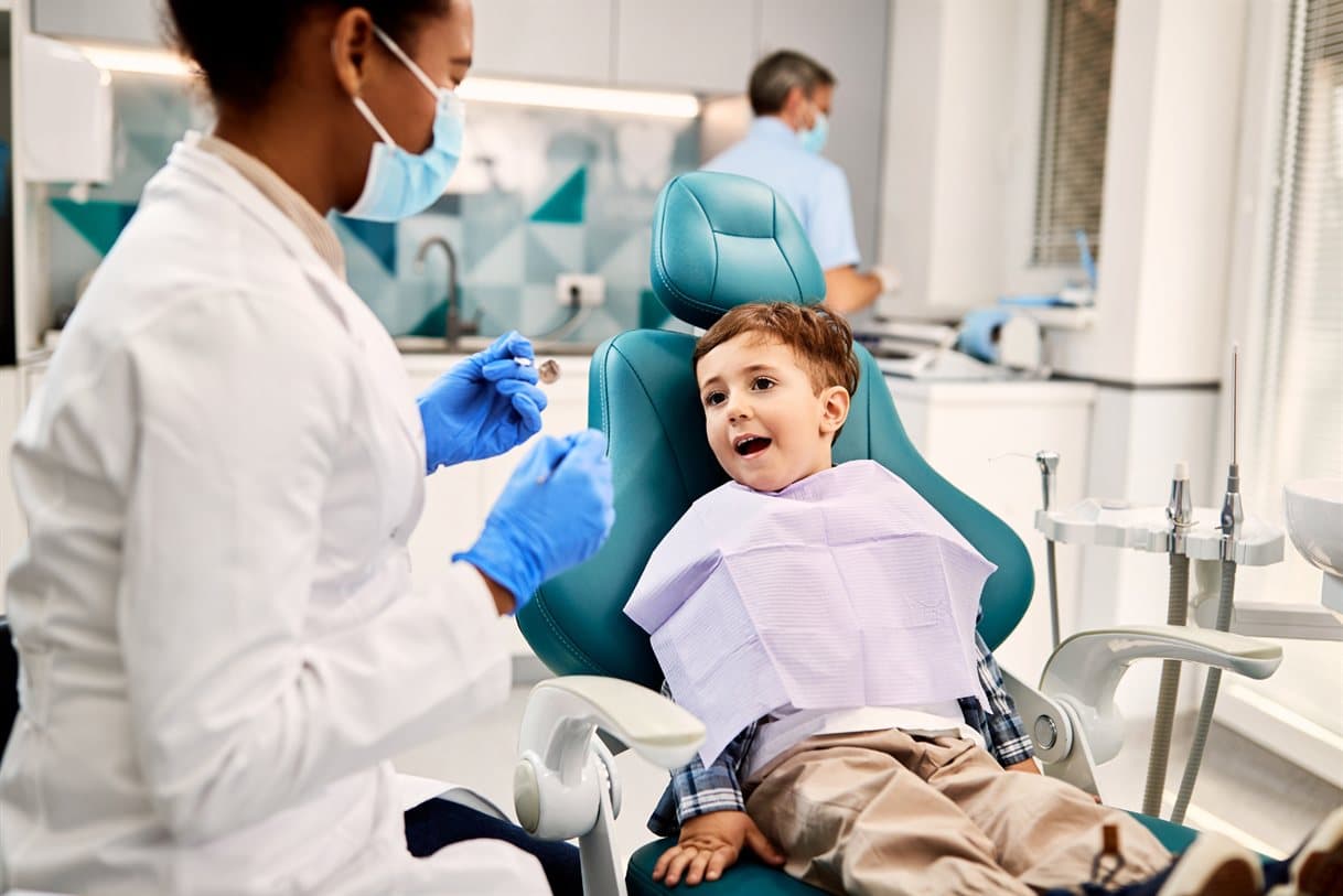 A dentist with a young patient in the dental chair